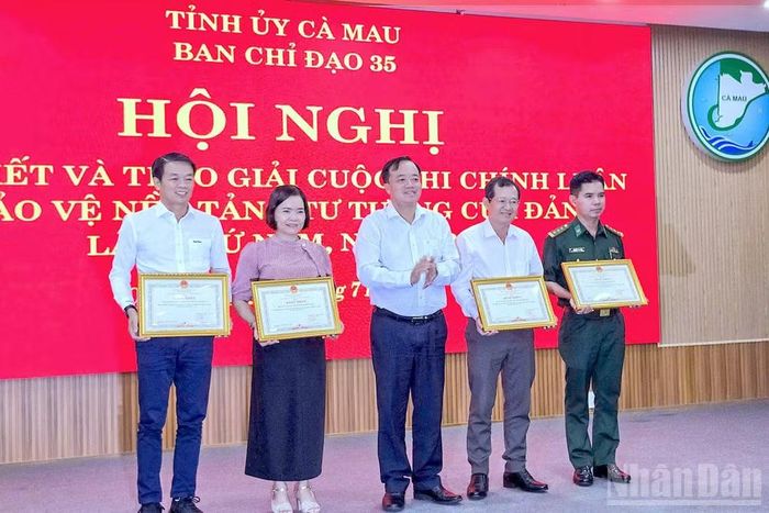 Phó Bí thư Thường trực Tỉnh ủy Cà Mau Huỳnh Quốc Việt (đứng giữa) trao khen thưởng cho 4 tập thể xuất sắc.