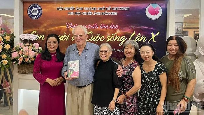 Các khách mời, nghệ sĩ nhiếp ảnh chụp ảnh lưu niệm tại triển lãm.