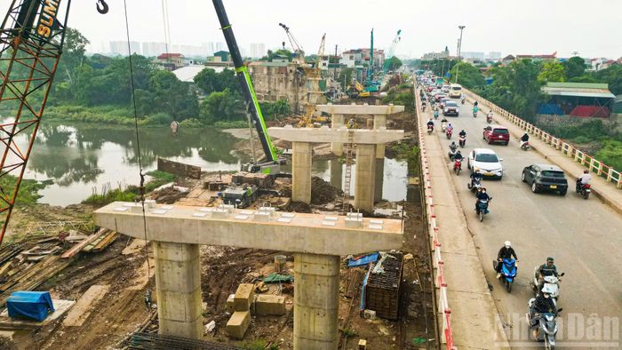 Các hạng mục móng và trụ cầu đang được đẩy nhanh tiến độ. Nhiều trụ giữa sông Đáy đã hoàn thành phần bê tông, từng bước hình thành diện mạo cây cầu mới.