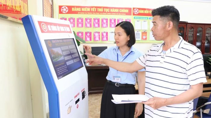 Công chức Trung tâm Phục vụ hành chính công xã Kim Thành, thành phố Hải Phòng, hướng dẫn người dân làm thủ tục hành chính. (Ảnh: TTXVN)