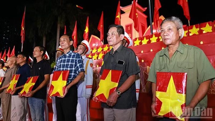 Đại diện gia đình, người thân liệt sĩ nhận di ảnh phục dựng tại buổi lễ. (Ảnh: Văn Tuyến)