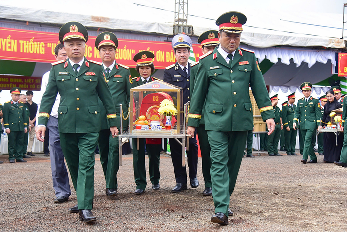  Các đại biểu thực hiện nghi thức đưa hài cốt liệt sĩ về khu vực nhà quàn. 