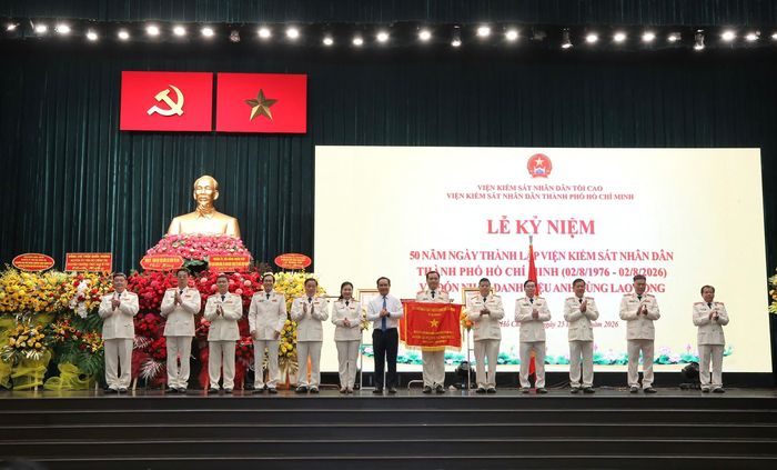 Chủ tịch UBND TPHCM Nguyễn Văn Được tặng Cờ truyền thống cho VKSND TPHCM. Ảnh: DŨNG PHƯƠNG