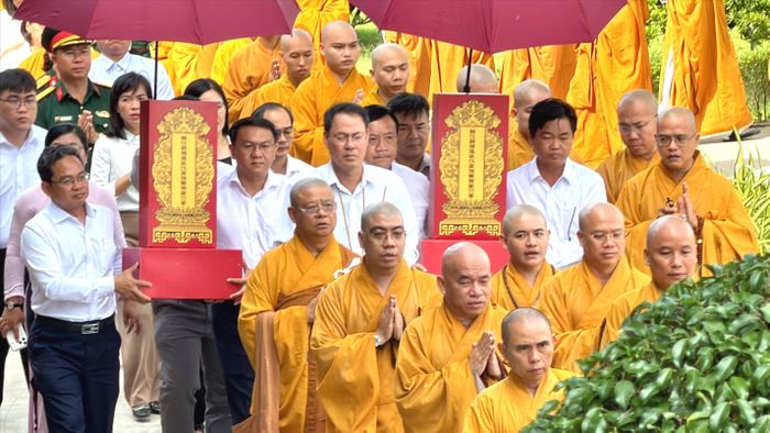 Chư tôn đức tăng ni cùng đại biểu thực hiện nghi thức cung thỉnh Linh vị Anh hùng liệt sĩ vào chánh điện Học viện Phật giáo Việt Nam tại TPHCM (xã Bình Lợi) Ảnh: HOÀNG HÙNG