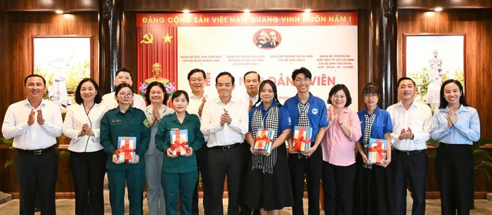  Bí thư Thành ủy TPHCM Trần Lưu Quang cùng lãnh đạo TPHCM trao quà chúc mừng các đảng viên mới. Ảnh: VIỆT DŨNG 