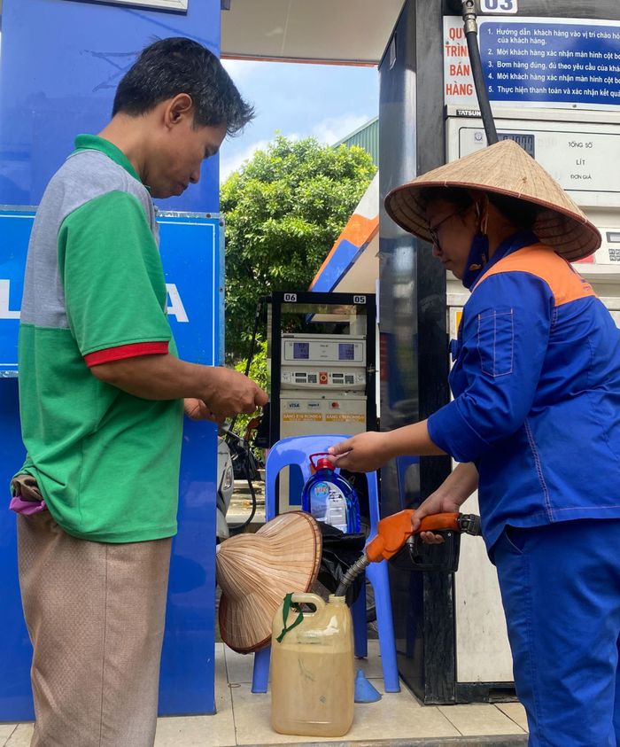  Người dân mang can đến mua xăng dự trữ sáng 25-7. Ảnh: PHÚC HẬU 