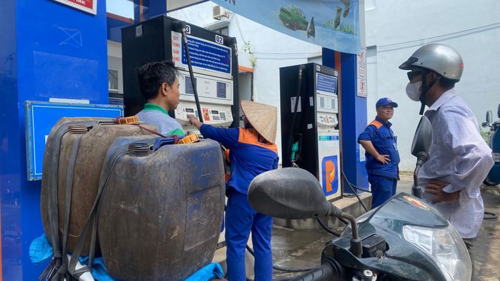  Người dân mang can đến mua xăng dự trữ sáng 25-7 tại cửa hàng xăng dầu Petrolimex Quốc Oai (TP Hà Nội). Ảnh: PHÚC HẬU 