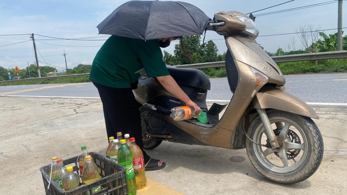  Không tìm được điểm đổ xăng, người dân phải mua xăng lề đường, sáng 25-7. Ảnh: PHÚC HẬU 