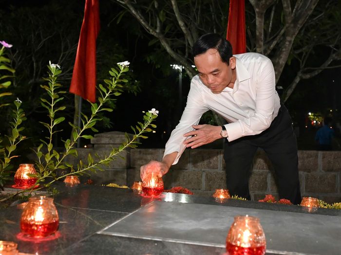 Bí thư Thành ủy TPHCM Trần Lưu Quang thắp nến tri ân Anh hùng, liệt sĩ tại nghĩa trang Hàng Dương. Ảnh: VIỆT DŨNG