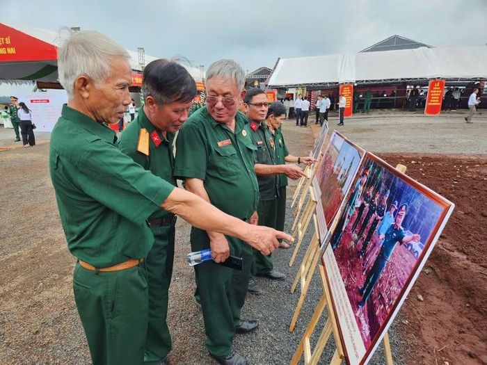 Các cựu chiến binh sinh sống trên địa bàn thành phố Đồng Nai cùng nhau xem các bức ảnh về quá trình tìm kiếm, quy tập hài cốt liệt sĩ tại khu vực xã Minh Đức.