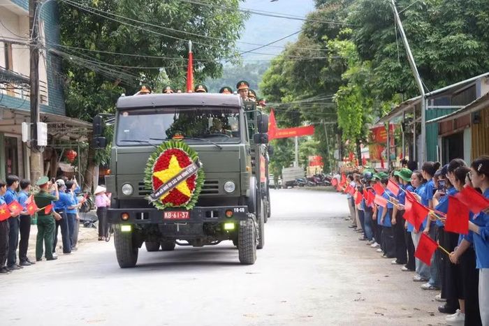 Người dân, cựu chiến binh, học sinh đứng kín 2 bên đường đưa tiễn hài cốt các liệt sĩ.