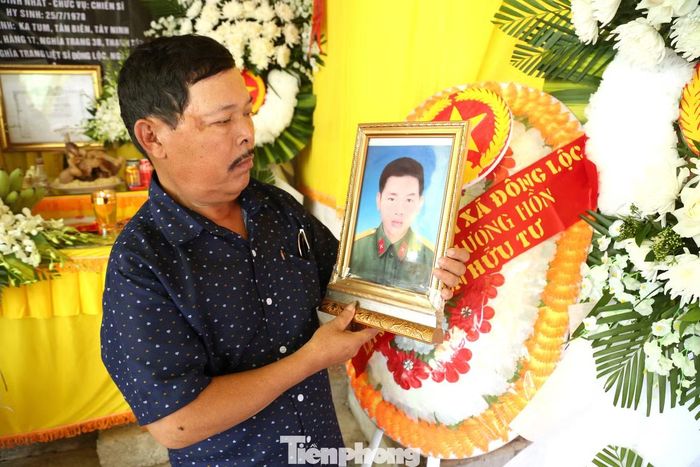 Ông Nguyễn Hữu Bình bên di ảnh anh trai liệt sĩ Nguyễn Hữu Tư.
