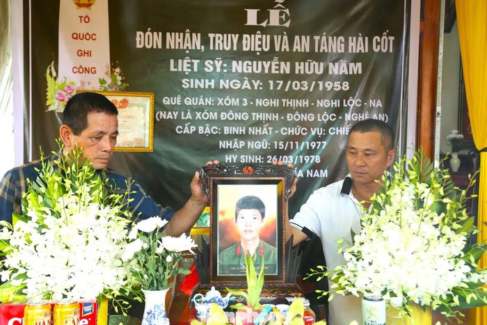 Hai anh em Nguyễn Hữu Mão và Nguyễn Hữu Hợi (phải) bên di ảnh anh trai liệt sĩ Nguyễn Hữu Năm.