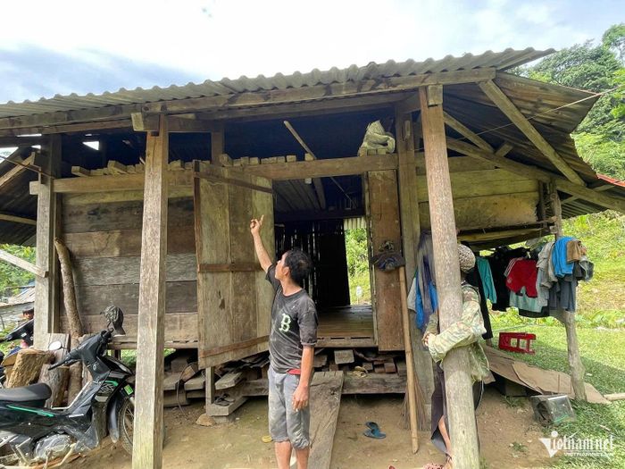 Anh Đoàn Duy Điệp bên căn nhà gỗ ép cũ của gia đình. Ảnh: Huy Trường