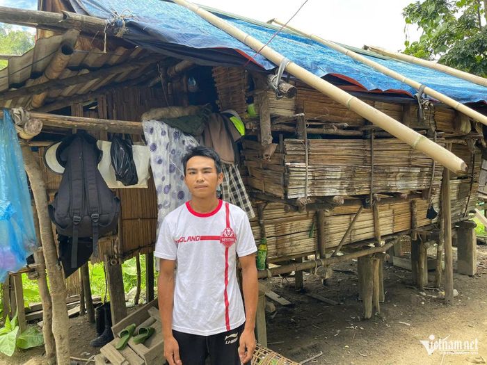 Anh Nguyễn Đình Điện bên căn nhà phên tre, vách gỗ đã nhiều năm. Ảnh: Huy Trường