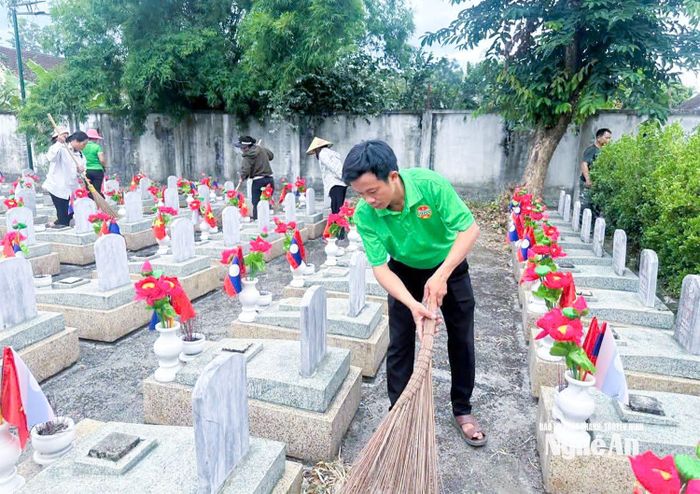 Cán bộ và nhân dân xã Anh Sơn tham gia chỉnh trang, làm vệ sinh tại Nghĩa trang Liệt sĩ quốc tế Việt – Lào. Ảnh: CSCC