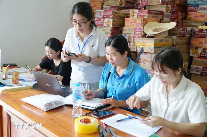 Kiểm đếm nhu yếu phẩm, tiền mà các nơi ủng hộ cho bà con vùng lũ Mường Than. (Ảnh: Nguyễn Oanh/TTXVN)
