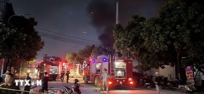 Cột khói đen bốc cao hàng trăm mét khiến người dân trong khu vực hoảng loạn. Lực lượng chức năng đang khẩn trương triển khai công tác nhằm dập tắt đám cháy. (Ảnh: Phan Tuấn Anh/TTXVN)