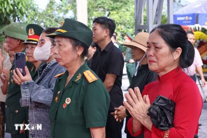 Tình cảm của người dân khi chứng kiến lễ các hài cốt liệt sỹ được quy tập về Nghĩa trang liệt sỹ Quốc gia Vị Xuyên, sẵn sàng cho lễ truy điệu và an táng chiều 26/7. (Ảnh: Hoàng Hiếu/TTXVN)