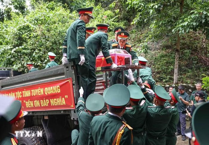 Đưa hài cốt 34 liệt sỹ di từ nhà chờ Đội tìm kiếm, quy tập hài cốt liệt sỹ tỉnh Tuyên Quang lên xe để di chuyển về Nghĩa trang liệt sỹ Quốc gia Vị Xuyên. (Ảnh: Hoàng Hiếu/TTXVN)