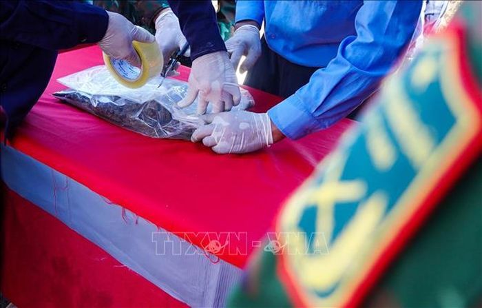 Lực lượng chức năng niêm phong các di vật tìm thấy tại vị trí chôn cất liệt sĩ Nguyễn Thị Út.