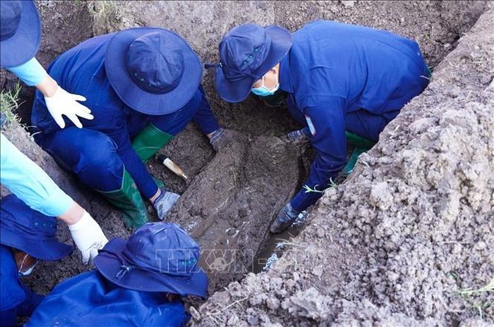Lực lượng chức năng tìm kiếm hài cốt liệt sĩ Nguyễn Thị Út dưới hố khai quật từ thông tin do ông Trần Văn Quận cung cấp.