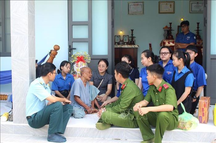 Các bạn đoàn viên, thanh niên quây quần bên Mẹ Việt Nam Anh hùng Lương Thị Con để nghe những câu chuyện lịch sử.