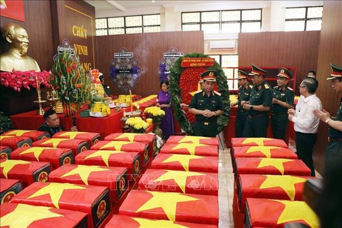Đại tướng Phan Văn Giang xúc động bên các hòm quách hài cốt liệt sĩ mới tìm thấy tại công viên Lê Thị Riêng. Ảnh: Xuân Khu/TTXVN