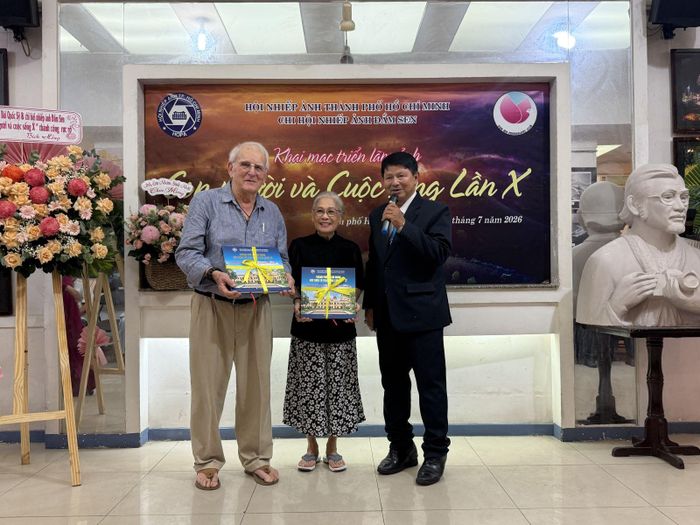 NSNA Đoàn Hoài Trung, Chủ tịch Hội Nhiếp ảnh TP Hồ Chí Minh tặng sách ảnh và giao lưu cùng vợ chồng nhà báo, phóng viên chiến trường Carl Robinson.