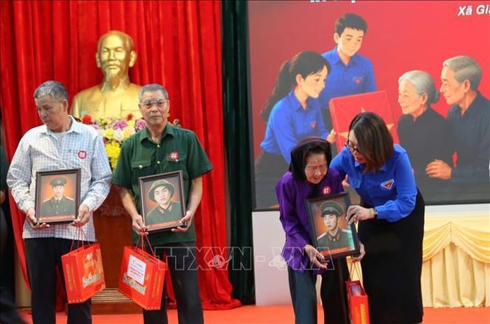 Chị Dương Thị Hương Giang, Phó Bí thư Thành đoàn Hải Phòng trao di ảnh liệt sĩ Bùi Đức Hãng, hy sinh năm 1969 tới vợ của Liệt sĩ.