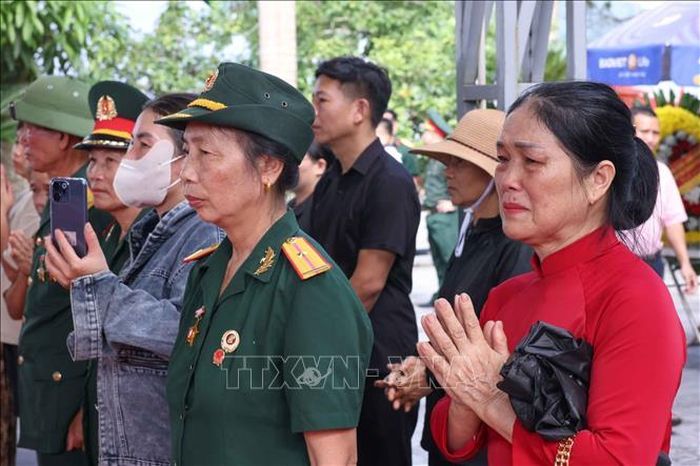 Tình cảm của người dân khi chứng kiến lễ các hài cốt liệt sĩ được quy tập về Nghĩa trang liệt sĩ Quốc gia Vị Xuyên, sẵn sàng cho lễ truy điệu và an táng chiều 26/7. Ảnh: Hoàng Hiếu/TTXVN