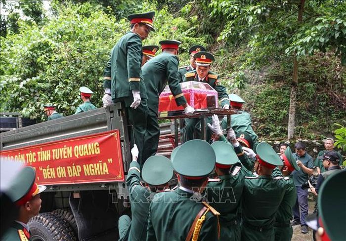 Đưa hài cốt 34 liệt sĩ di từ nhà chờ Đội tìm kiếm, quy tập hài cốt liệt sĩ tỉnh Tuyên Quang lên xe để di chuyển về Nghĩa trang liệt sĩ Quốc gia Vị Xuyên. Ảnh: Hoàng Hiếu/TTXVN.