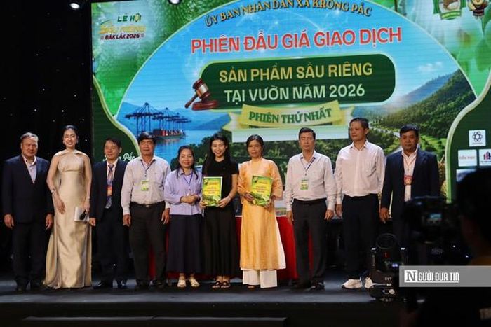 Đại diện doanh nghiệp trúng đấu giá và đại diện chủ vườn ký biên bản sau phiên đấu giá.