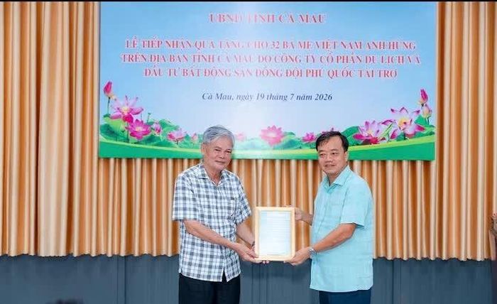 Ông Trương Minh Chiến (bên trái) được ông Huỳnh Quốc Việt - Phó Bí thư Thường trực Tỉnh ủy Cà Mau trao thư cảm ơn của Bí thư Tỉnh ủy Cà Mau Nguyễn Hồ Hải.