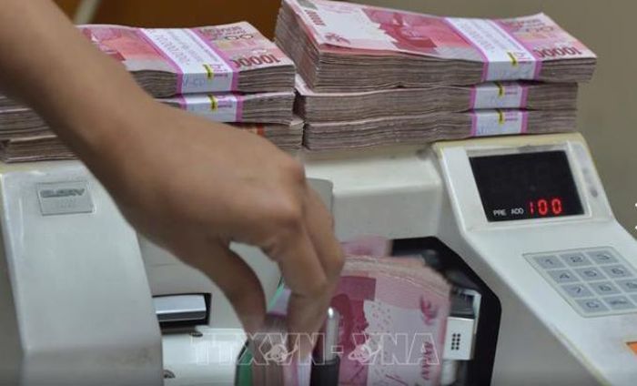 Nhân viên văn phòng giao dịch hối đoái kiểm đếm tiền giấy rupiah tại Indonesia. Ảnh minh họa: TTXVN phát
