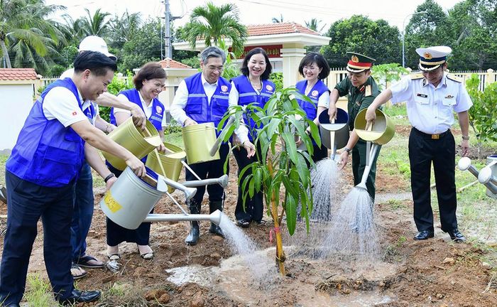 Các đại biểu và cán bộ, chiến sĩ Trạm Ra đa 590 chung tay gieo trồng, chăm sóc công trình "Vườn cây Đại đoàn kết"