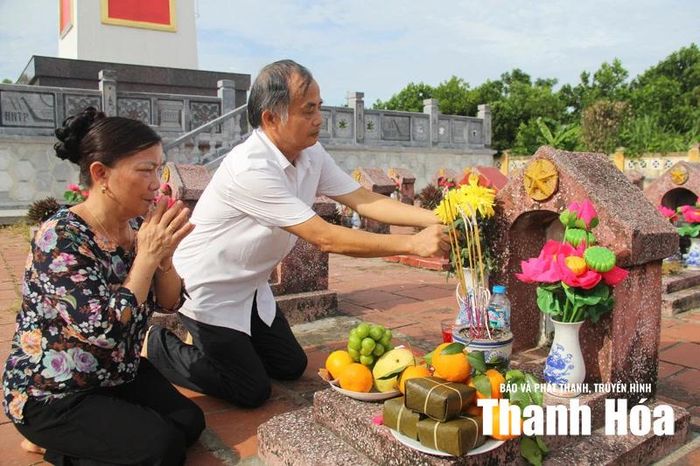 Vợ chồng ông bà Nguyễn Hữu Bình, Lê Thị Thoa thắp thương cho cha - liệt sĩ Lê Văn Đảm yên nghỉ tại Nghĩa trang Liệt sĩ Quảng Xương.