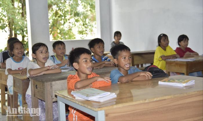 Các em học sinh chăm chú đọc tiếng Khmer trong lớp học tại chùa.