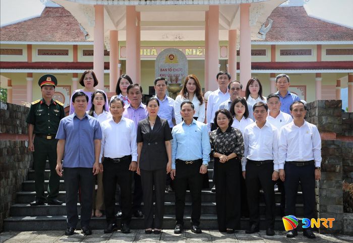 Đoàn công tác chụp ảnh lưu niệm tại bia di tích Khu lưu niệm Ban Tổ chức Khu ủy Khu V. Ảnh: ALĂNG NGƯỚC