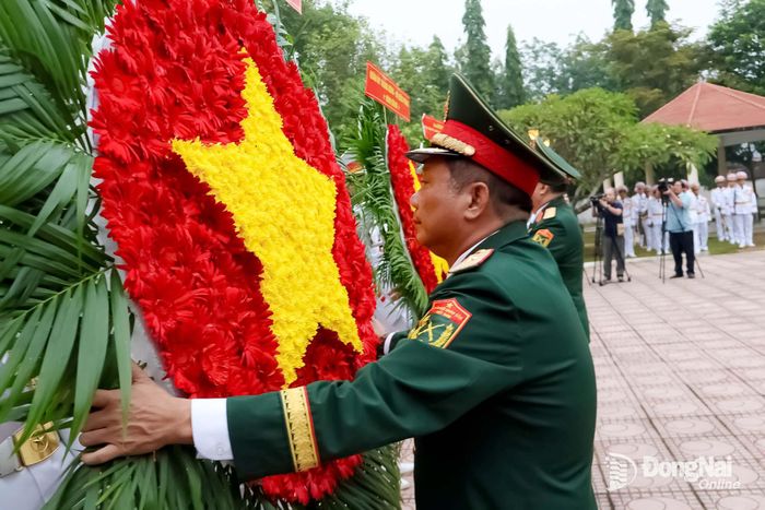 Thiếu tướng Trần Chí Tâm, Phó Chính ủy Quân khu 7, Trưởng ban Chỉ đạo Quân khu về tìm kiếm, quy tập và xác định danh tính hài cốt liệt sĩ chỉnh hoa trước khi viếng liệt sĩ. Ảnh: Nguyệt Hà