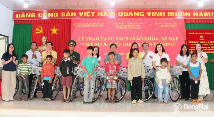 Đại diện Chi bộ Phòng Thư ký biên tập, Báo và Phát thanh, Truyền hình Đồng Nai, Trung tâm Ngoại ngữ và Tin học Astra và lãnh đạo xã Bù Gia Mập tặng xe đạp cho các học sinh khó khăn. Ảnh: Quang Minh