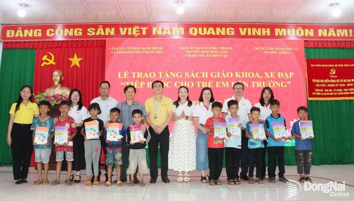 Đại diện Chi bộ Phòng Thư ký biên tập, Báo và Phát thanh, Truyền hình Đồng Nai, Trung tâm Ngoại ngữ và Tin học Astra và lãnh đạo xã Bù Gia Mập tặng sách giáo khoa cho các học sinh khó khăn. Ảnh: Quang Minh