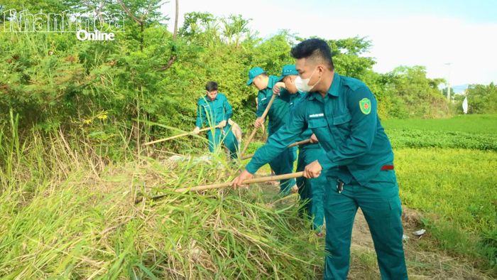 Lực lượng dân quân tham gia phát quang cây cỏ khu vực sông Tháo.