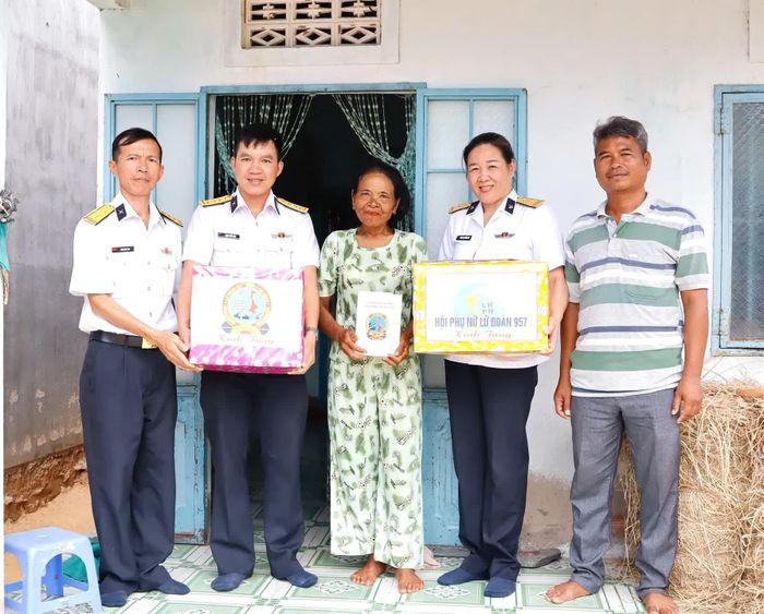Đại diện Lữ đoàn 957 và Hội Phụ nữ lữ đoàn tặng quà cho bà Thị Hiệp.