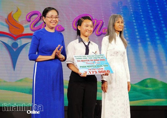 Bà Nguyễn Thị Minh Hồng tặng sổ tiết kiệm cho em Phan Nguyễn Ngọc Hân.