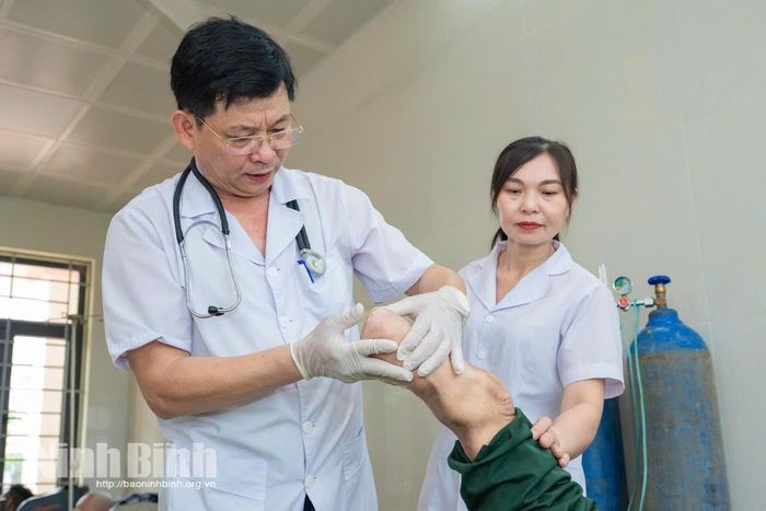 Bác sĩ Đinh Lệnh Dự kiểm tra, thăm khám vết thương cho thương binh nặng tại cơ sở Điều dưỡng thương binh Nho Quan.