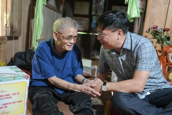 Đồng chí Thiếu tướng Nguyễn Thanh Liêm, Giám đốc Công an tỉnh thăm, tặng quà ông Hồ Khiên, thân nhân liệt sĩ, trú tại bản K-Vi, xã Dân Hóa - Ảnh: T.T