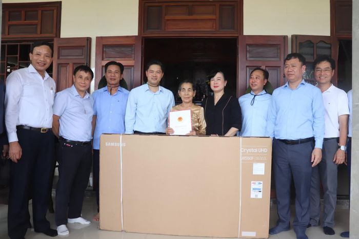Đồng chí Đào Hồng Lan, Bộ trưởng Bộ Y tế tặng quà gia đình bà Lê Thị Huê, thương binh 2/4, thương tật 61% tại xã Vĩnh Định - Ảnh: T.P