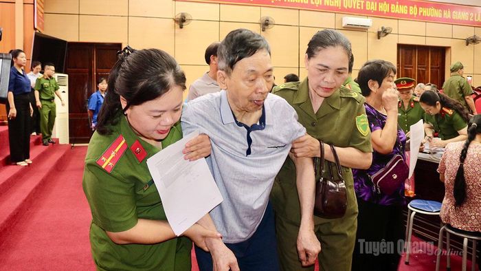 Lực lượng Công an hỗ trợ thân nhân liệt sĩ cao tuổi trong quá trình thực hiện thu nhận mẫu sinh phẩm ADN.