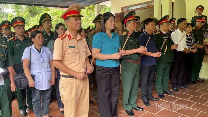 Các đại biểu thực hiện thủ tục chuẩn bị di chuyển hài cốt liệt sĩ từ Nhà quàn Đội tìm kiếm, quy tập hài cốt liệt sĩ (thôn Giang Nam, xã Thanh Thủy) về Nghĩa trang liệt sĩ Vị Xuyên. Ảnh Bang Phúc